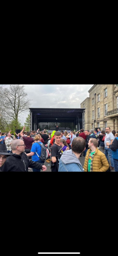 8x6 Trailer stage Crowd of people gathered at an outdoor event with a large stage in the background.