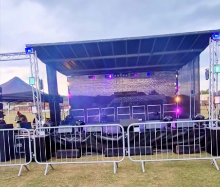 6x4 Trailer stage Stage set up for an outdoor event, featuring sound equipment and seating barriers.